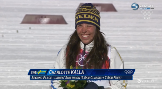En sprudlande glad Charlotte Kalla tar emot blomster på pallen | Viaplay.se